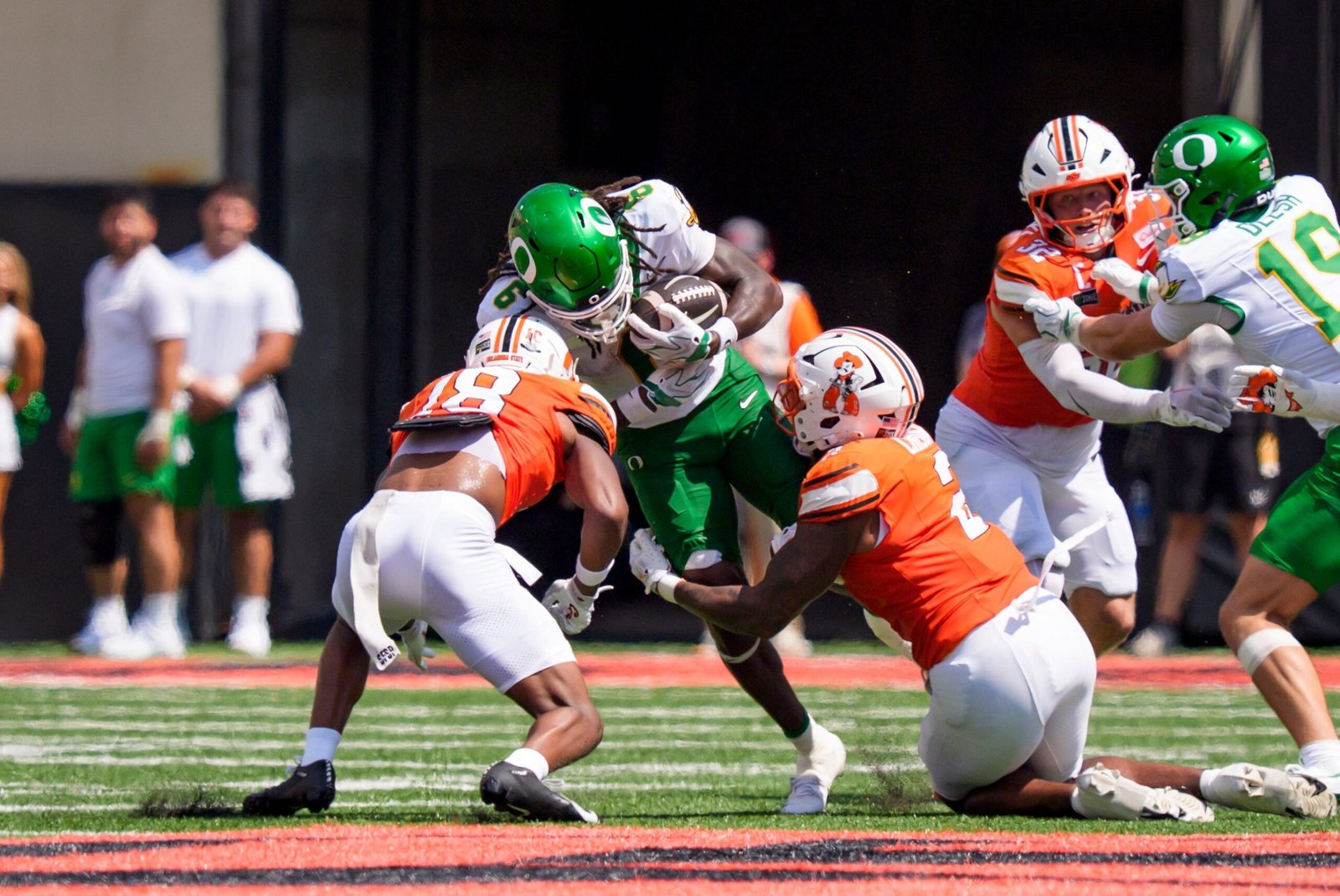 Oregon running back Dierre Hill Jr., center, is brought down by Oklahoma State safety Mose Phillips III, left, and linebacker Isaiah Chisom during their game at Boone Pickens Stadium in Stillwater, Okla.